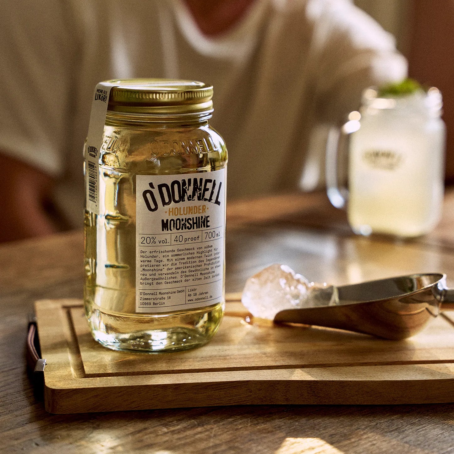 O'Donnell Moonshine Holunder-Likör mit einem Mason Jar vor einem angerichteten Cocktail.